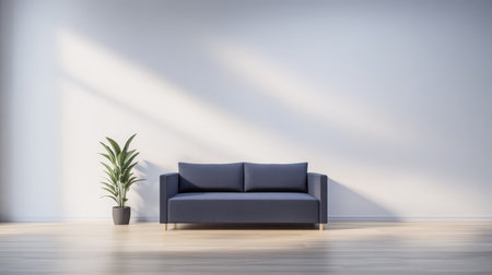 A minimalist living room features a modern blue sofa positioned against a light wall. An indoor plant in a pot adds a touch of nature.の素材