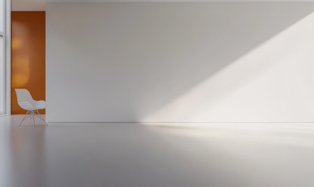 Bright and airy interior showcasing a minimalist design. A white chair sits in a corner with strong natural light casting shadows on the smooth floor. Vibrant orange wall adds a pop of color.の素材