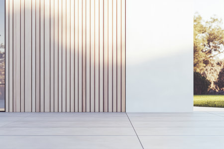A minimalistic architectural space features a wooden accent wall and a clean white wall. The garden outside is lush and illuminated by warm sunset light showcasing serene outdoor elements.の素材