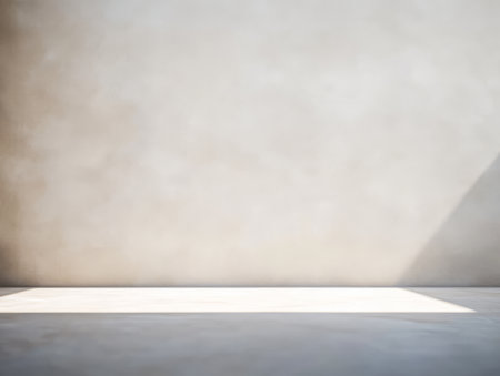A spacious studio features a smooth concrete floor bathed in soft natural light. The pale wall creates an inviting atmosphere perfect for creative activities or minimalistic settings.の素材