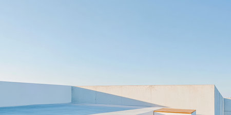 A spacious rooftop terrace features minimalist concrete walls and a wooden bench surrounded by clear blue sky. The scene conveys tranquility and simplicity perfect for relaxation.の素材