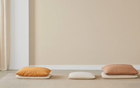 Soft cushions in warm tones are arranged neatly on a neutral rug enhancing a serene lounge area. The subtle colors create a calming atmosphere ideal for relaxation.の素材