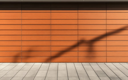A warm wooden wall with horizontal slats is contrasted by a long diagonal shadow cast on the pavement during the day. The clean lines and soft tones create an inviting urban atmosphere.の素材