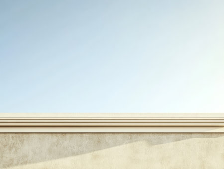A smooth light-colored wall stretches across the foreground under a clear blue sky creating a tranquil atmosphere. The sunlight casts soft shadows enhancing the minimalist aesthetic.の素材
