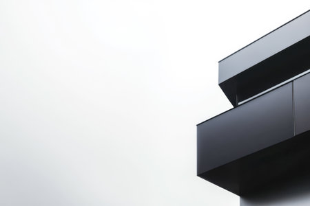 A sleek black building corner is visible against a gray overcast sky. The minimalist design emphasizes straight lines and a contemporary aesthetic creating a striking visual contrast.の素材
