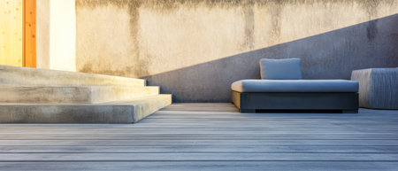 A modern outdoor lounge area features a sleek gray lounge chair and a comfortable cushion. The wooden deck and minimalist walls create a tranquil atmosphere in the evening light.の素材