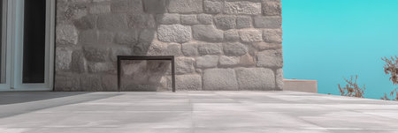 A minimalistic outdoor area features a stone wall and sleek tile flooring. The bright blue sky contrasts with the textured stone creating a tranquil atmosphere at a coastal setting.の素材