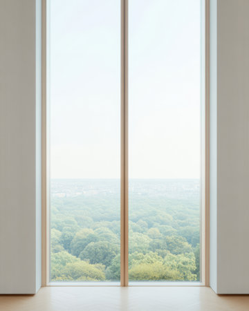 A spacious interior features a large window that reveals a serene view of lush green trees. The overcast sky adds a calm ambiance to the tranquil setting.の素材
