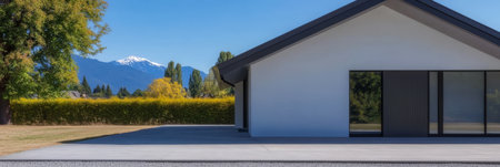 A contemporary house sits amid lush greenery with snow-capped mountains in the background. Bright blue skies dominate the scene creating a serene atmosphere ideal for peaceful living.の素材