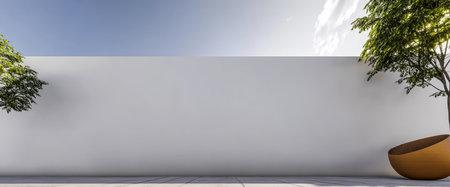 Bright and airy outdoor area featuring a smooth white wall and soft green foliage. The sun shines down in the early afternoon emphasizing the clean lines and serene atmosphere.の素材