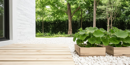 A wooden deck leads to a serene garden featuring neatly arranged planters filled with lush green plants. The bright space is surrounded by trees creating a peaceful atmosphere.の素材