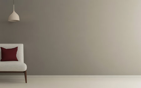 A cozy living room features a light-colored sofa with a burgundy pillow against a soft gray wall. A modern pendant light casts gentle illumination enhancing the serene atmosphere of the space.の素材