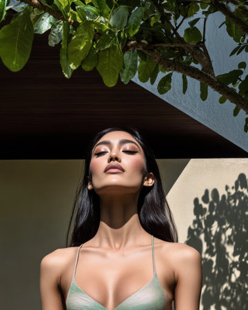 A model stands confidently in front of a contemporary structure showcasing a stylish outfit while basking in warm sunlight.の素材