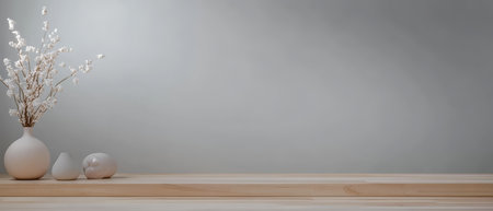A minimalist setup showcases a white vase with delicate flowers and a small decorative object on a wooden shelf against a soft gray wall. The arrangement enhances modern aesthetic appeal.の素材