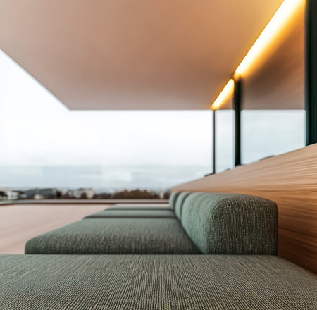 A stylish seating arrangement made of soft fabric is positioned against a large glass window. The space offers a breathtaking panorama of the landscape as the sun sets.の素材