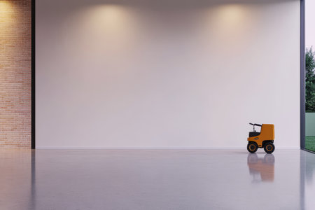 A bright spacious room features a smooth floor and a large blank wall. A small yellow toy vehicle is positioned in the corner creating a playful yet minimalist atmosphere.の素材