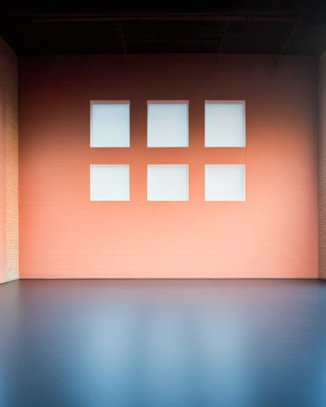 A spacious gallery features a polished floor and walls painted in soft colors. Large empty window frames invite natural light and serve as potential display areas for artwork.の素材