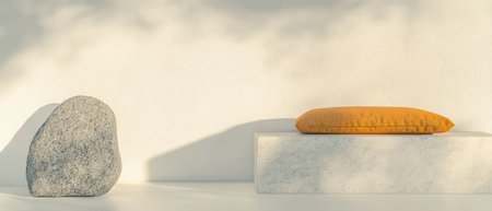 A smooth grey stone sits beside a warm yellow cushion placed on a white marble block showcasing a minimalist and calming interior design. The soft light evokes tranquility and harmony.の素材