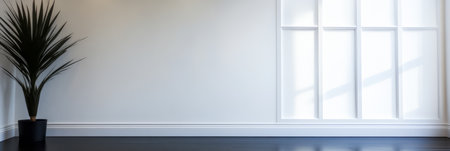 A spacious interior features a tall potted plant beside a large window. Bright natural light fills the room highlighting the clean lines and simplicity of the design.の素材