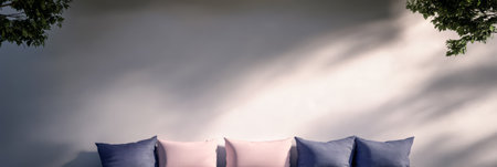 A serene seating area features a light wall and cushions in soft colors. The gentle shadows create a relaxing atmosphere ideal for enjoying time outdoors or unwinding with a book.の素材