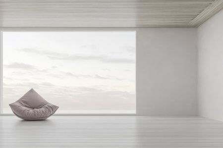 A minimalistic room features a soft bean bag chair positioned near a large window. Natural light fills the space highlighting the neutral tones and simplicity of the design.の素材