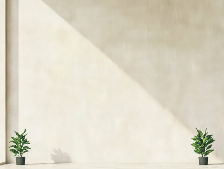 Two green potted plants stand on a light-colored floor against a smooth beige wall creating a tranquil and stylish atmosphere with distinct shadows in the warm sunlight.の素材