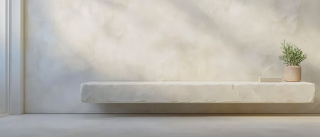 A minimalist space featuring a smooth floating shelf against a textured wall. A small potted plant and a few books rest on the shelf illuminated by natural light filtering in.の素材