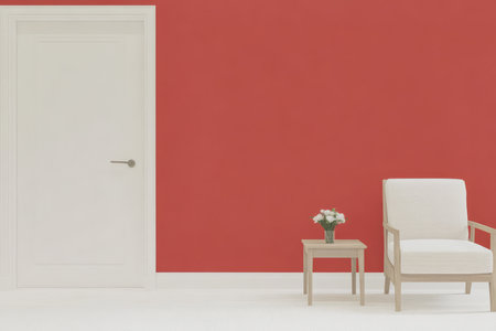 A bright room features a striking red wall that adds vibrancy. A simple white chair and a small table with flowers create a cozy and inviting atmosphere.の素材