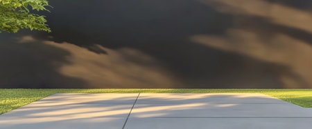 Soft morning light gently illuminates the clean smooth pavement in a modern outdoor area. A minimalistic backdrop creates a serene atmosphere with greenery nearby enhancing the tranquil vibe.の素材
