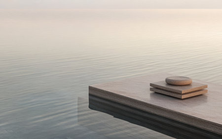 Gentle morning light casts a warm glow on smooth stones arranged on a sleek surface at the edge of a still lake. Soft ripples create a peaceful atmosphere inviting relaxation and reflection.の素材