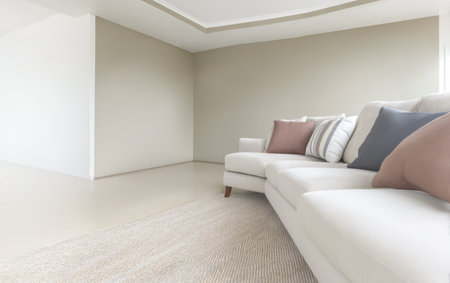 This living room showcases a contemporary design with a light-colored sofa adorned with decorative pillows. The walls are painted in soft neutrals creating a serene and inviting atmosphere.の素材