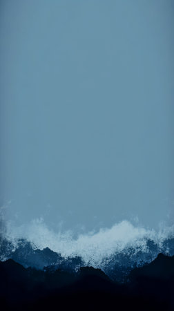 The turbulent sea smashes against rugged rocks sending white foam into the air. The sky is overcast giving a dramatic backdrop to the powerful ocean.の素材