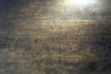 A rustic wooden surface exhibits intricate textures and scratches enhanced by gentle lighting that casts warm tones creating an inviting atmosphere perfect for artistic presentations.の素材