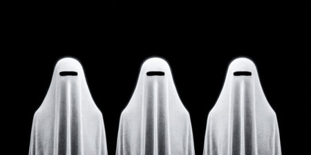 Three figures cloaked in white fabric create a ghostly presence in a dimly lit space. Their blackened faces evoke a sense of mystery and intrigue during an eerie gathering.の素材