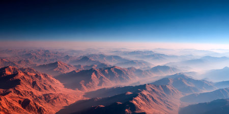 An expansive view of mountains captured from above during early morning. Soft light illuminates the peaks and valleys, showcasing their natural beauty and tranquility.の素材