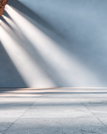 Bright beams of sunlight create striking shadows on the cool, gray floor of a spacious, uncluttered room. The atmosphere feels calm and inviting in the afternoon light.の素材