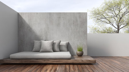 This outdoor space showcases a minimalist lounge area on a wooden deck. A large cushion serves as seating, accompanied by decorative pillows and a small plant, all under a clear sky.の素材