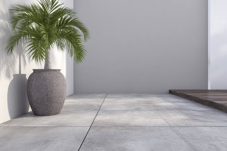 A well-designed outdoor area showcases a large pot holding a vibrant palm plant. The gray wall provides a simple backdrop, while wooden decking adds warmth to the scene.の素材