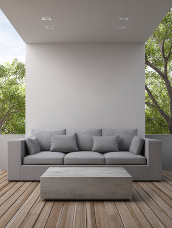 A stylish outdoor space features a gray couch with plush cushions and a simple concrete table. Bright greenery surrounds the area, creating a serene atmosphere for relaxation.の素材