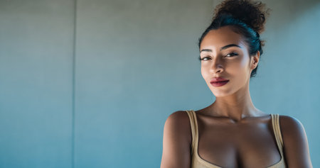 A model with a confident expression showcases a fashion-forward outfit in a studio setting. Soft lighting enhances her features and highlights the simplicity of the background.の素材