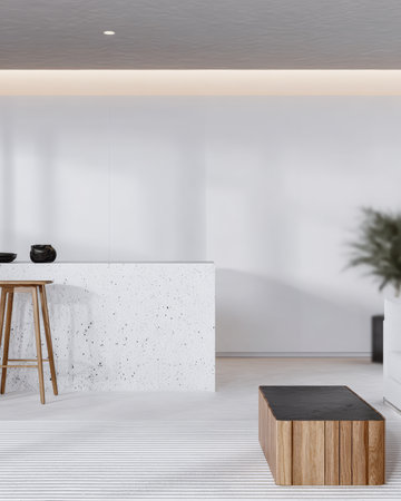 A modern kitchenette features a white speckled counter and wooden stools. The space is bright with soft lighting, showcasing minimalist aesthetics and clean design.の素材