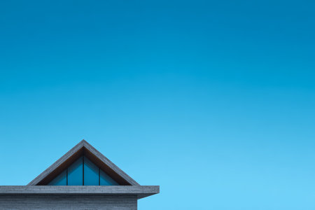 A contemporary building features a unique triangular roof with large windows, set against a bright blue sky. The scene captures the essence of modern architecture and tranquility.の素材