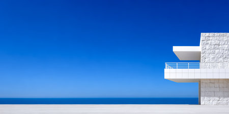 A striking modern building overlooks the ocean under a vivid blue sky. The sleek architecture features a spacious balcony and simple geometric forms, emphasizing tranquility and beauty.の素材