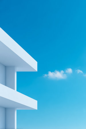 A striking view of a modern building structure against a vibrant blue sky. Soft clouds drift lazily, enhancing the serene atmosphere of this coastal setting.の素材