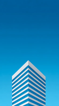 A striking building with blue and white stripes rises against a vivid blue sky. The structure features a sleek modern design, showcasing its architectural elegance.の素材