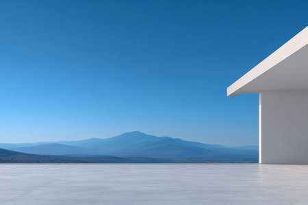 A minimalist building stands on a smooth terrace with a breathtaking view of distant blue mountains under a clear sky. The scene captures a serene and peaceful atmosphere.の素材