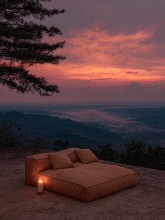 A mountain top offers a stunning sunset view. A cozy seating area with soft cushions is illuminated by a warm candle, creating a peaceful setting to relax and enjoy nature.の素材