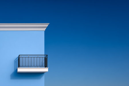 A striking blue wall rises against a vibrant sky, featuring a simple balcony that adds charm. The scene conveys tranquility and invites admiration of architecture and nature.の素材