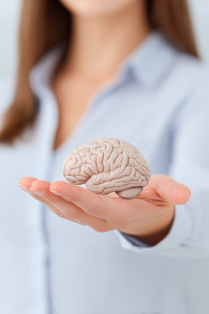 A person stands indoors, extending their hand to display a realistic brain model. This scene highlights the importance of brain health and education in a clinical or academic setting.の素材