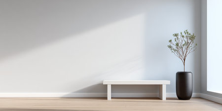 A serene interior showcases a white bench beside a tall black vase with a slender plant. Soft sunlight streams in, creating a peaceful atmosphere in the minimalist space.の素材